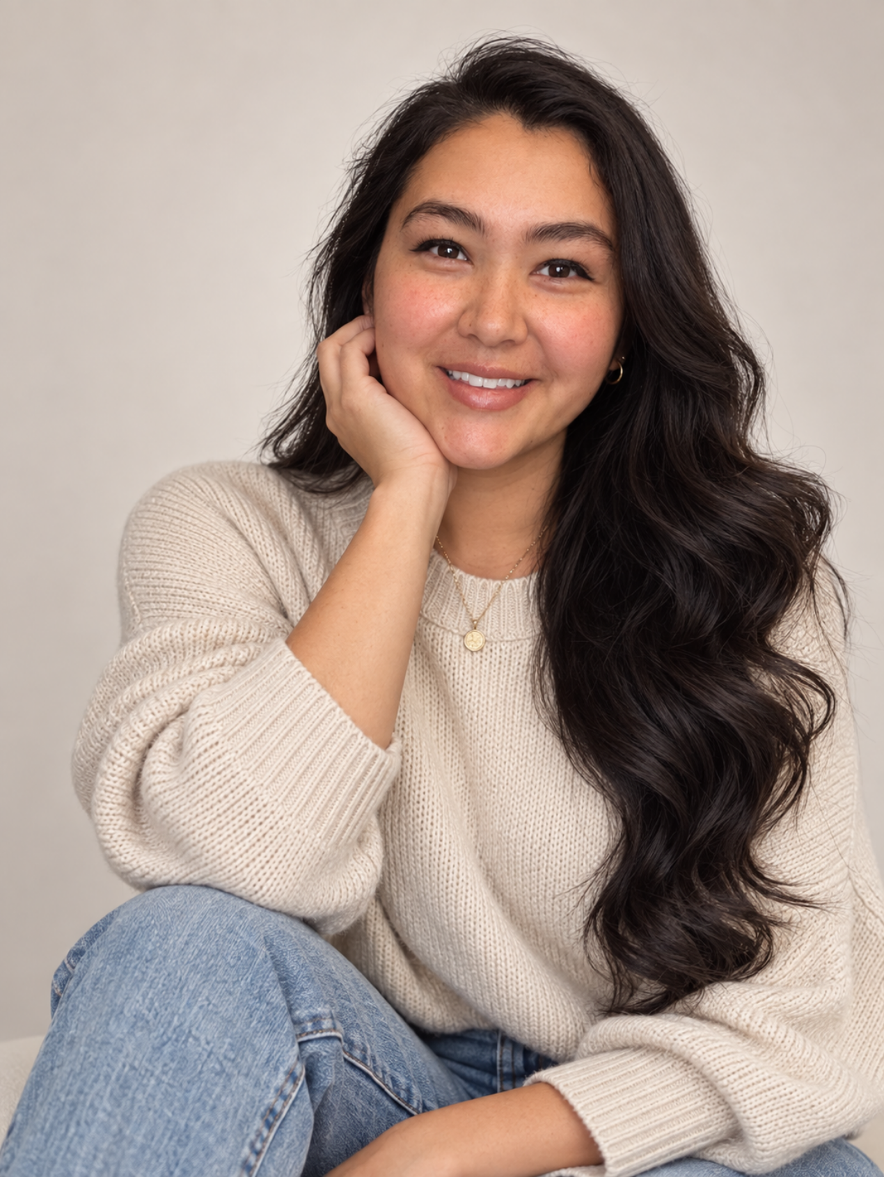 Alicia seated in a cream sweater